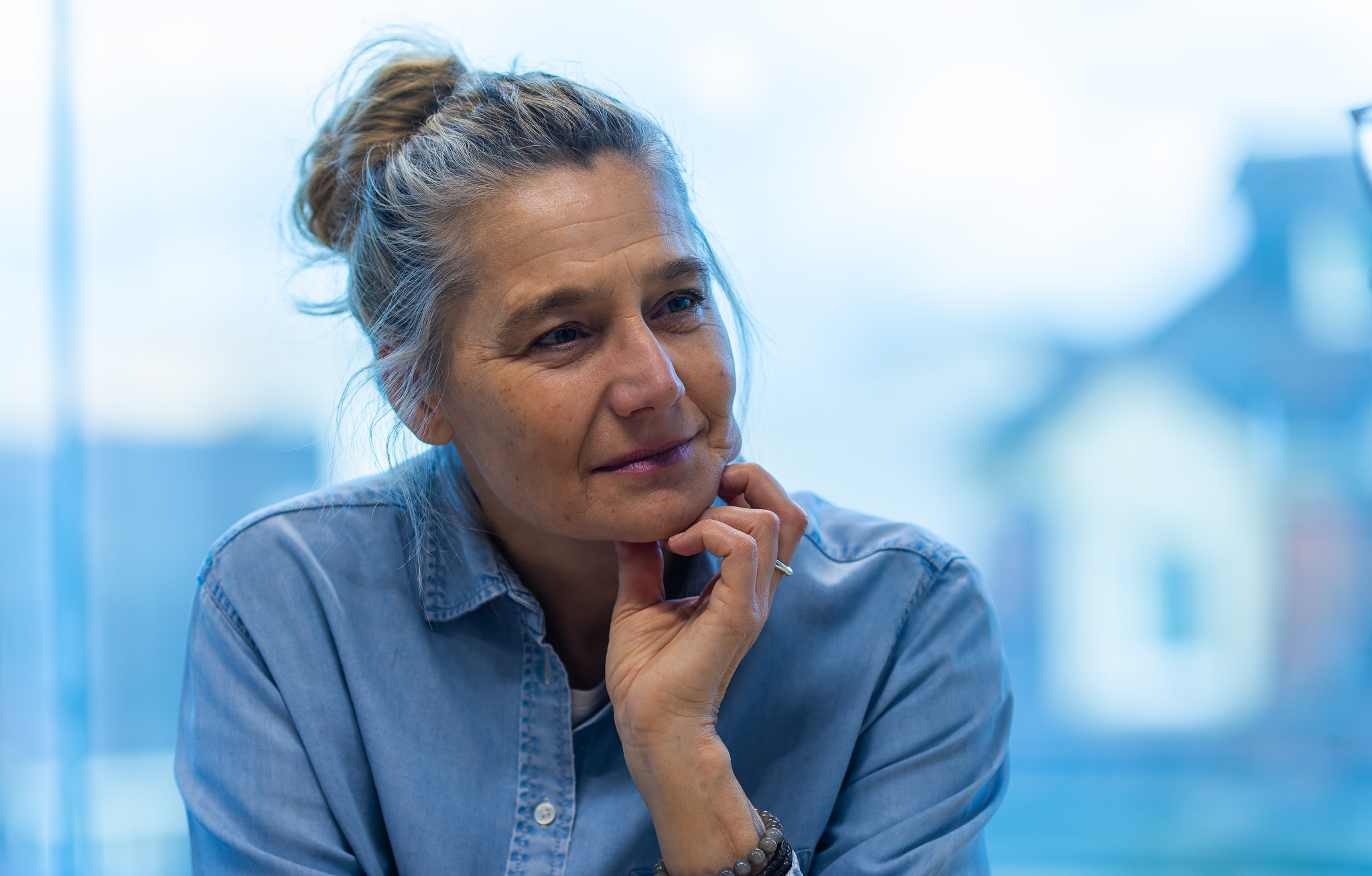 Business Frau lächelnd in ein Gespräch vertieft im Büro von Bornhauser People's Management als Headhunter Zürich