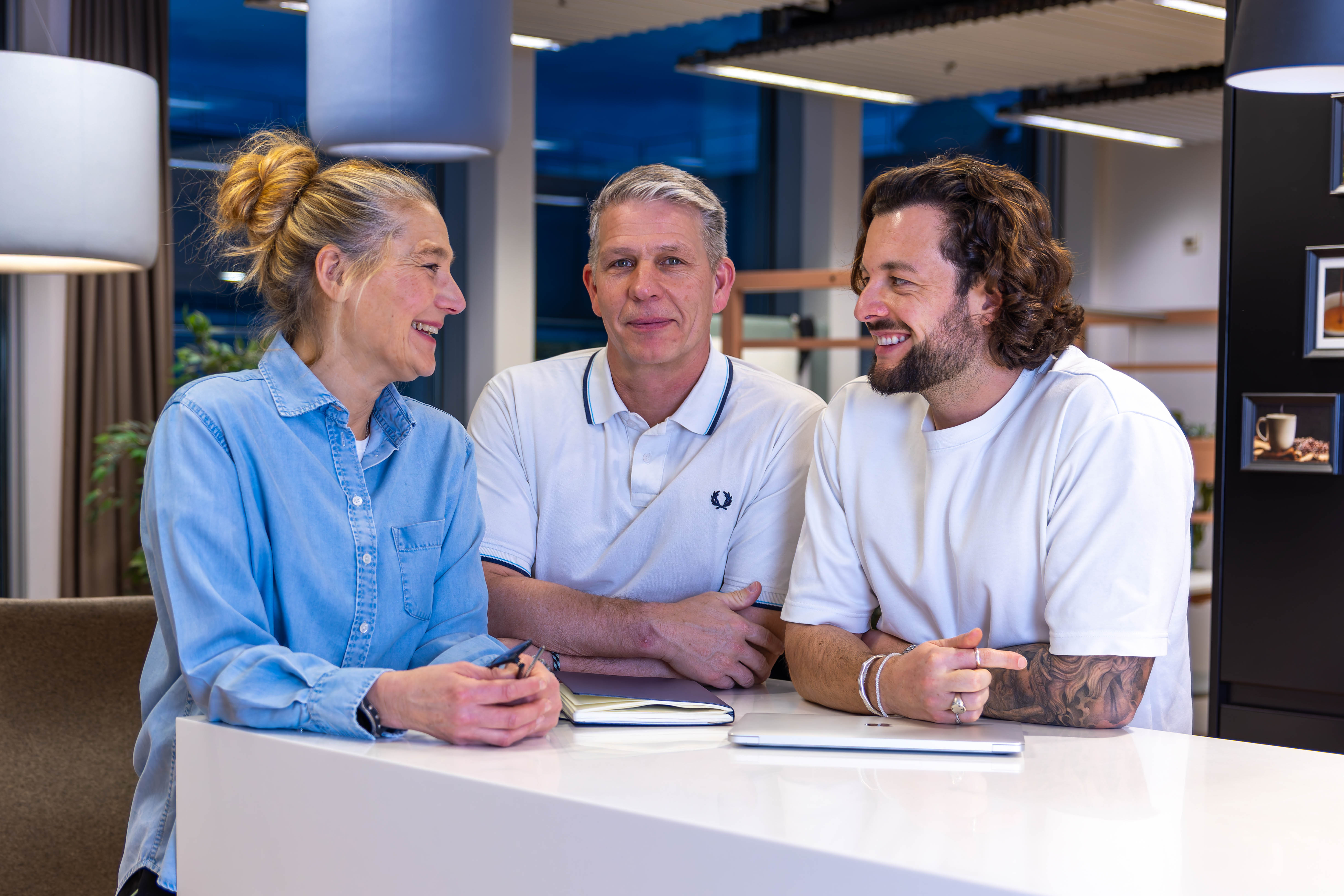 Angestellte von Headhunter und Personalberatung von Bornhauser Peoples Management, die während des Arbeitstages an einem Stehtisch stehen.
