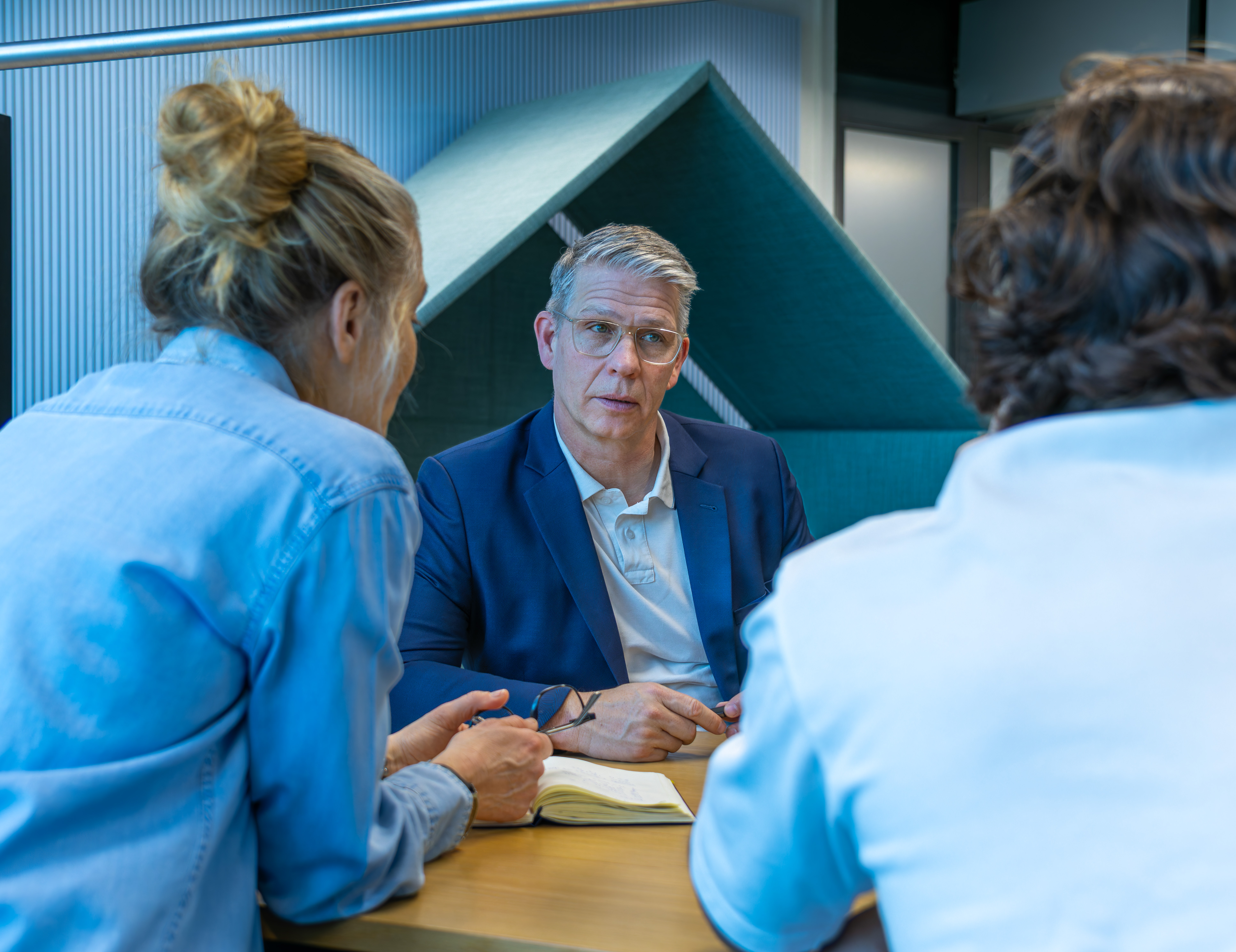 Business Mann sitzt zusammen mit seinen Personalberater am Tisch mit Unterlagen für ein Meeting von top Headhunter Zürich